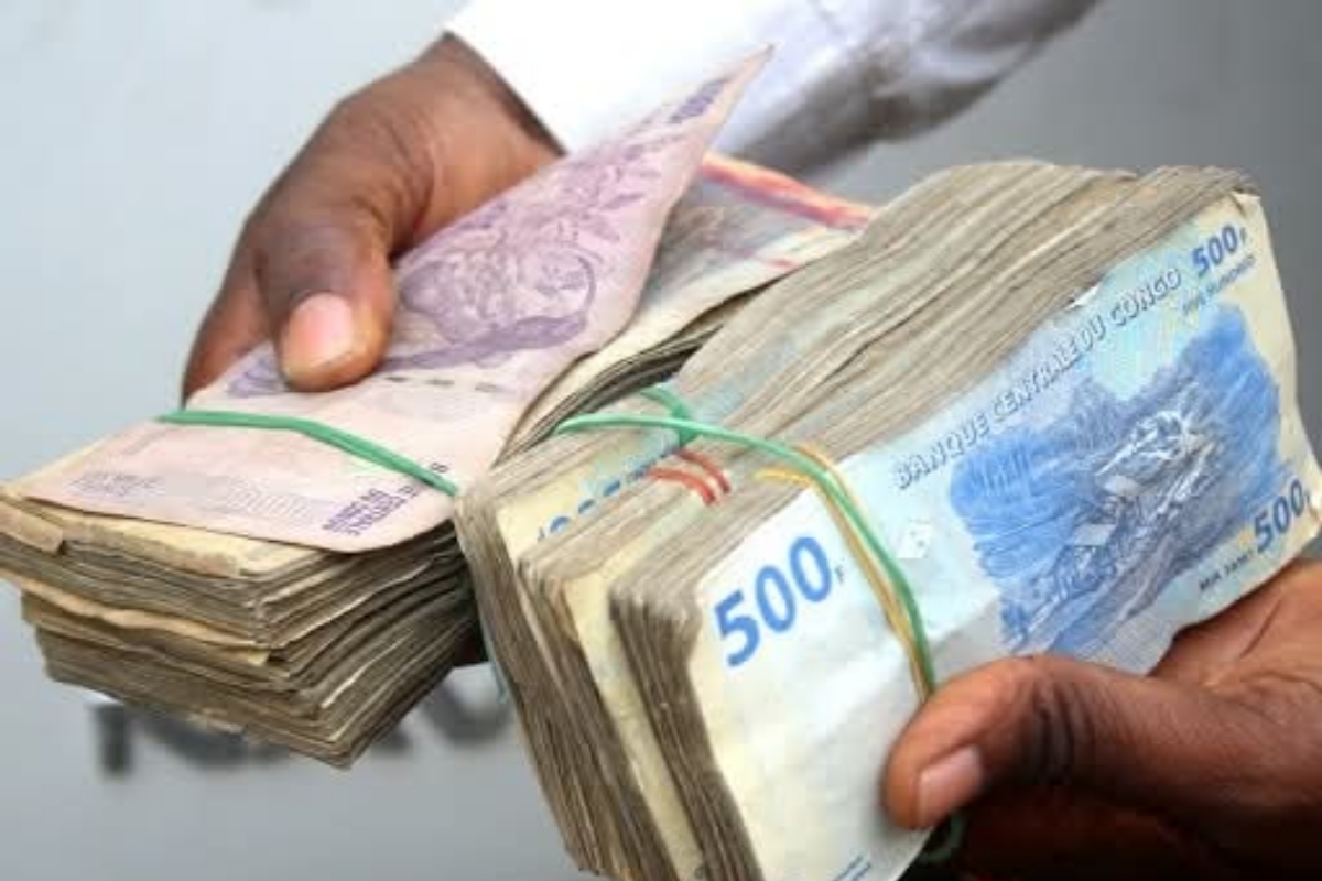 Illustration,  billets du franc congolais tenu par un échangeur de monnaie